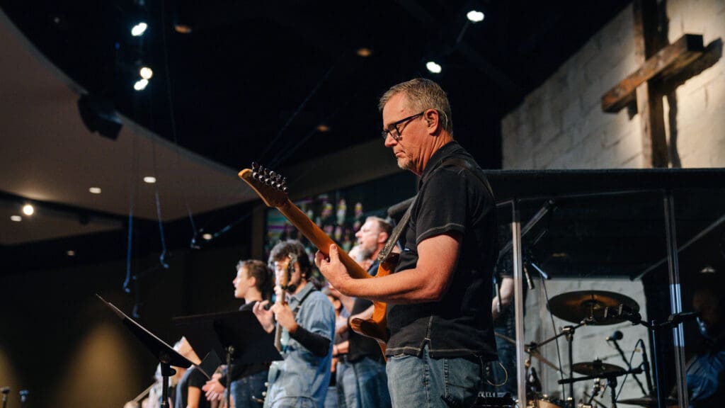 Worship Arts volunteer playing the guitar.